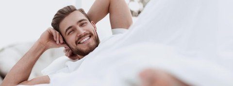 uśmiechnięty mężczyzna w pościeli n69.pl blog