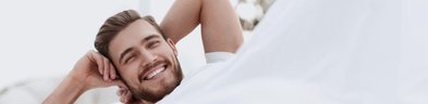 uśmiechnięty mężczyzna w pościeli n69.pl blog