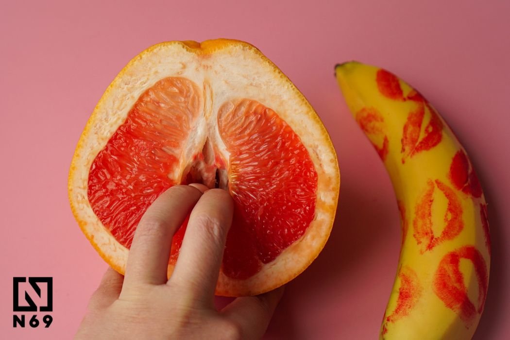grapefruit z palcem, usta na bananie